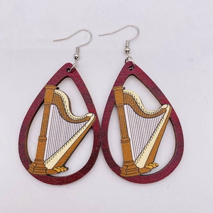 Detailed close-up of teardrop wooden earrings featuring a golden harp inlay design
