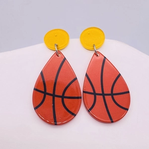 Detail of tear-drop basketball patterned acrylic earrings with yellow circular accent