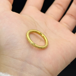 Anello in acciaio al titanio placcato oro 18k con incisione tradizionale in mano