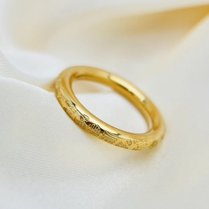 Dettaglio macro dell'anello in acciaio al titanio placcato oro 18k con incisione Fu