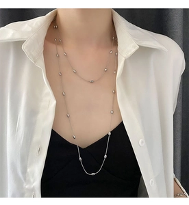 Dettaglio della collana a strati in argento con perle ovali lucide sulla modella