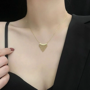 Gouden titanium stalen ketting met kwastjes hanger en kralenketting op model in zwart pak