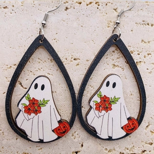 Dettaglio di orecchini in legno di Halloween con stampa fantasma e zucca su pietra