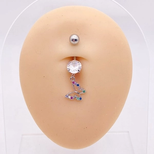 Detalle de piercing de ombligo en acero con colgante de mariposa y circonitas de colores
