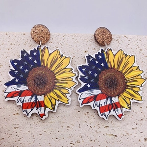 Independence Day wooden earrings with sunflower and American flag pattern on stone background