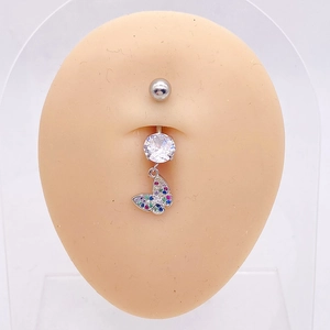Detalle de un piercing para ombligo de mariposa plateada con circonitas de colores