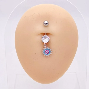 Detalle de piercing para ombligo de acero con colgante de girasol azul en un modelo