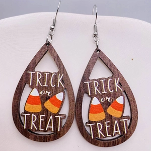 Dettaglio di orecchini di legno Halloween con scritte Trick or Treat e caramelle