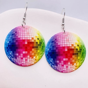Close-up of round acrylic earrings with rainbow pixel disco ball pattern on a white tray