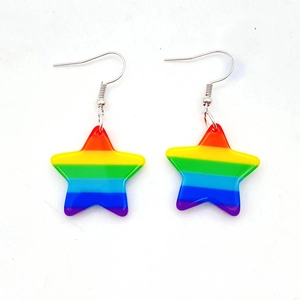 Detail of star-shaped acrylic drop earrings featuring colorful rainbow stripe patterns