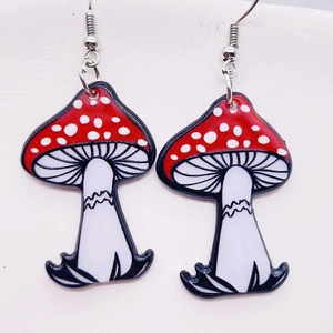 Close-up of red and white spotted mushroom acrylic dangle earrings with silver hooks