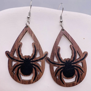 Dettaglio macro di orecchini a goccia in legno con motivo a ragno per Halloween