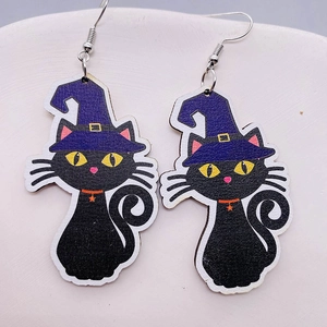 Primo piano di orecchini di Halloween in legno con gatto nero e cappello da stregone