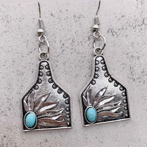 Vue détaillée des boucles d'oreilles style étiquette en argent avec feuilles et turquoise