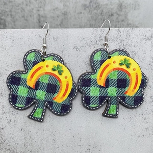Detalle de pendientes de trébol con cuadros verdes y motivo de herradura amarilla