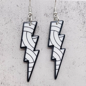 Détail de boucles d'oreilles éclair en acrylique avec texture noire et crochets argent