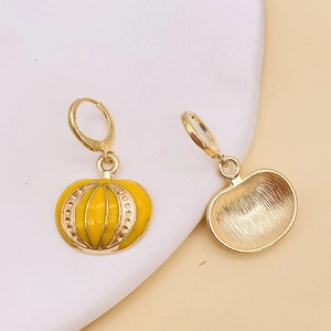 Detalle macro de pendientes de calabaza con acabado de esmalte y reverso dorado texturizado