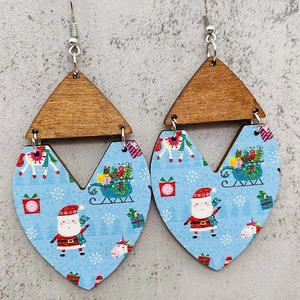 Pendientes navideños de madera con motivos de Papá Noel sobre un fondo gris con textura fina