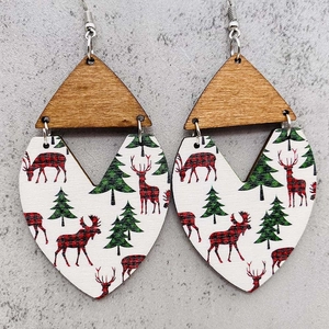 Detalle de pendientes navideños de madera con motivos de reno y pino en dijes de corazón