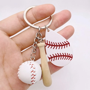 Close-up of a mini baseball keychain set with wooden bat and red-stitched leather ball