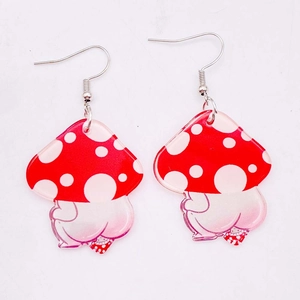 Detailed close-up of acrylic red mushroom earrings with creative white polka dot design