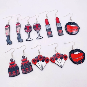 Macro detail of acrylic Halloween earrings featuring scary skull and blood drop motifs