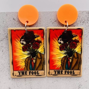 Detail of The Fool tarot card drop earrings with orange studs and cowboy art