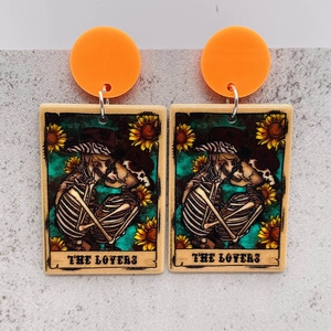 Detail of tarot card earrings featuring skeleton lovers and sunflowers for Halloween