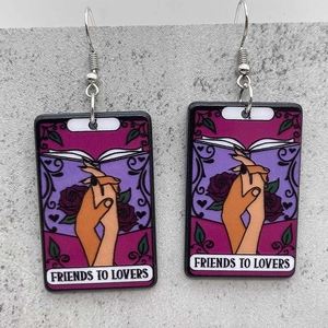 Detail of tarot card earrings featuring friends to lovers text and purple roses