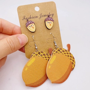 Detail view of acorn and pine cone themed earrings set on a jewelry display card