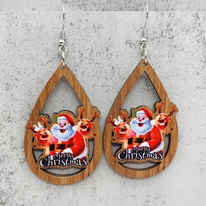 Vista macro detallada de los pendientes de gota de madera con Papá Noel y diseño de renos