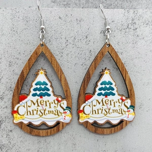 Detalle de pendientes de gota de madera con árbol de Navidad y diseño de muñeco