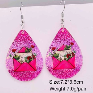 Detail von roten Rosen- und Liebesbriefmustern auf rosa Paillettenohrringen