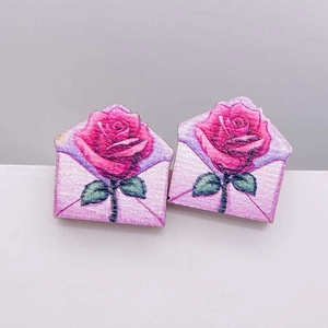 Detalle de pendientes de madera con ilustración de rosas rosas y sobre romántico