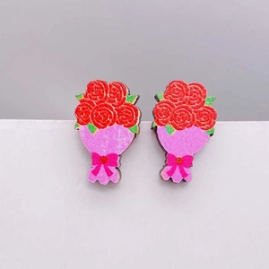 Detalle de pendientes de madera con ramo de rosas con envoltorio rosa y lazo rojo decorativo