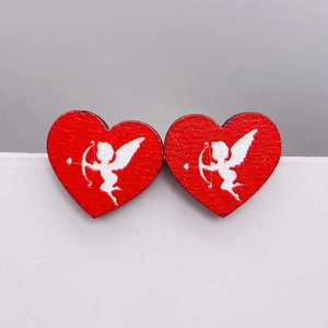 Detalle de pendientes de corazón de madera roja con silueta blanca de Cupido
