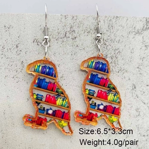 Detailaufnahme der vogelförmigen Acryl-Ohrringe mit buntem Bücherregal-Design