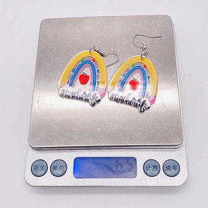 Detailed macro view showing a teacher acrylic earring weighing 6.5g on a digital scale