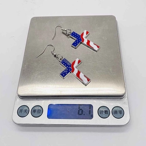Dettaglio orecchini a croce con bandiera americana e indicazione del peso di 6,1g