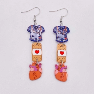 Nurse scrub suit and stethoscope acrylic heart earrings with medical charms on gray background