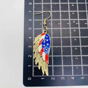 Dettaglio orecchini ad ala con colori bandiera americana su tappetino graduato