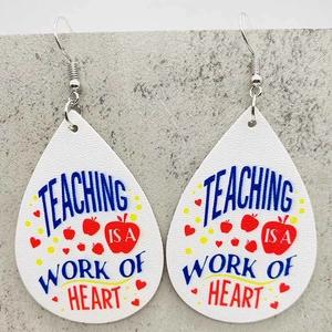 Dettaglio orecchini a goccia con stampa a cuore mela e frase Teaching is a Work of Heart