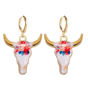 Detalle de pendientes de cabeza de toro floral con cuernos dorados y motivos de esmalte