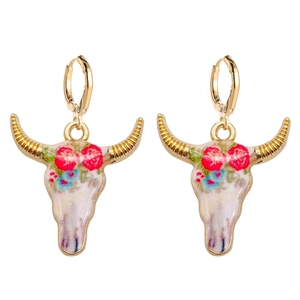Detalle de pendientes de aro dorados con colgantes de calavera de toro y motivos florales