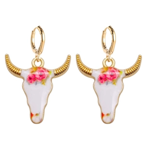 Detalle de los pendientes de calavera de toro boho con flores rosas y cuernos dorados