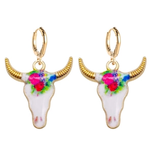 Detalle de pendientes de calavera de buey con estampado floral colorido y ganchos dorados