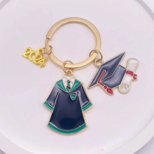 Detail of 2024 graduation keychain with golden academic cap, gown, and diploma charms