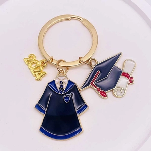 Detail of 2024 graduation keychain featuring graduation cap, scroll and blue gown charms
