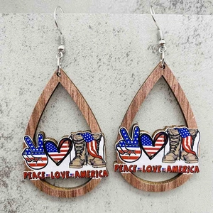 Detalle de pendientes de madera con gráficos de Peace Love America sobre piedra