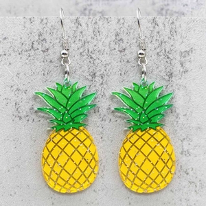 Primer plano de aretes de piña en acrílico con purpurina amarilla y hojas verdes
